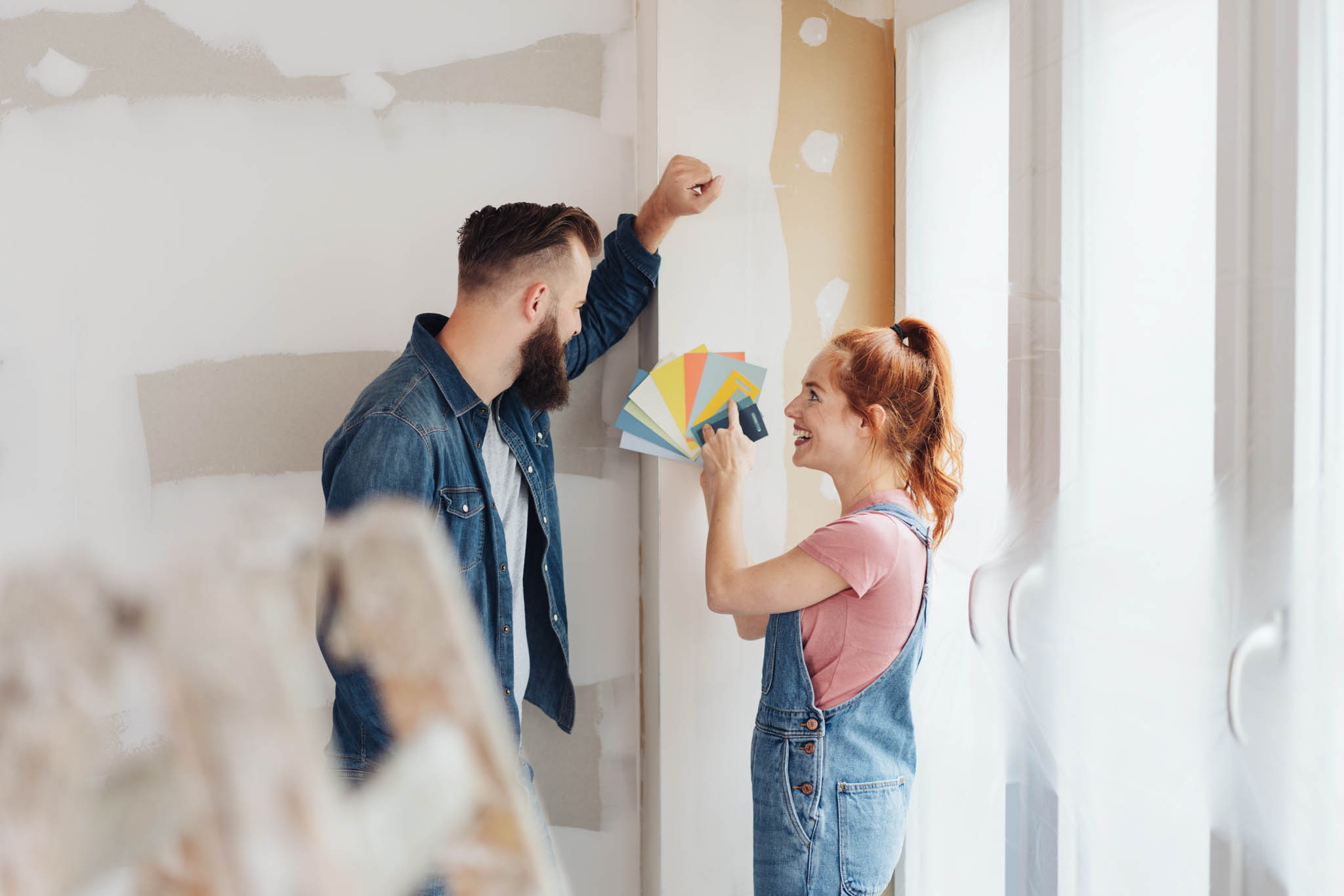 An image of a couple choosing what color to use for their home remodel - follow this guide from RiseCon North America to increase your home property value!